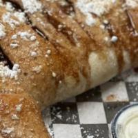 Blueberry Pie Calzone · Folded dough filled with blueberry pie filling and graham crackers. Topped with cinnamon but...