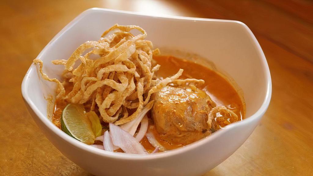 Khao Soi · Spicy. Red curry noodle soup. Egg noodle with chicken simmered in rich, creamy curry soup topped with crispy egg noodles, pickled mustard greens, red onion lime, and chili oil. Add chicken, tofu, vegetable, beef, shrimp, seafood for an additional charge.