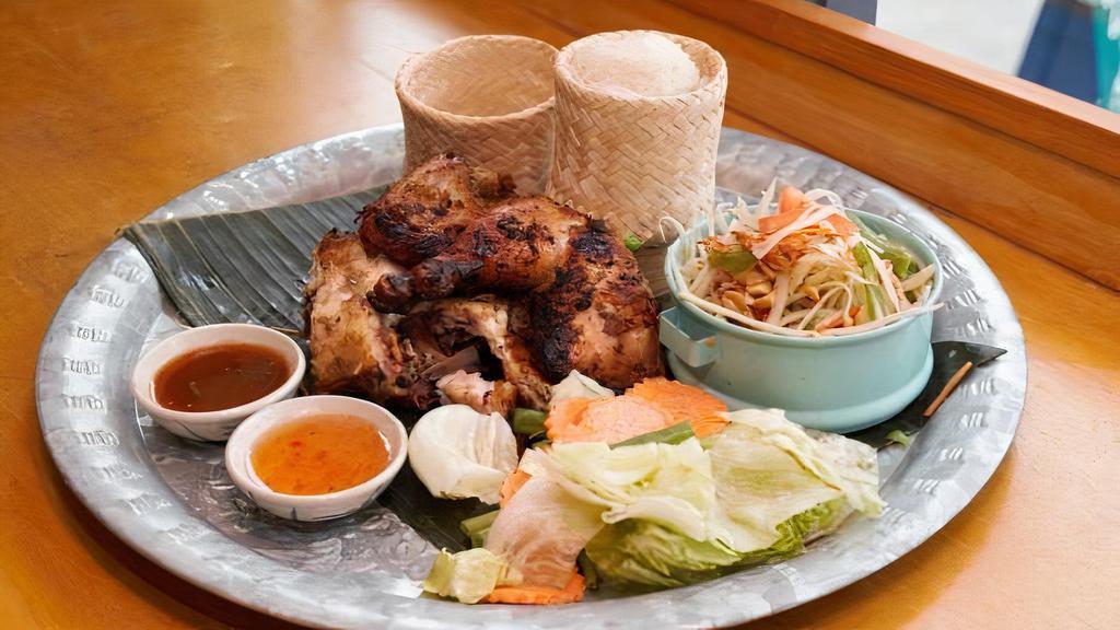 Gai Yang Khao San Kwang · Half chicken marinated with herbs and roasted to perfection served with papaya salad and sticky rice.