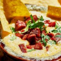 Queso Fundido With Chorizo · Mexican Monterey jack & Cheddar cheese fondue with chorizo and serrano salsa, served with co...