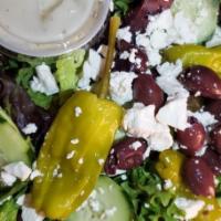 Mad Greek Salad · Feta cheese, kalamata olives, cucumbers, stuffed grape leaves and hot peppers with Greek Dre...