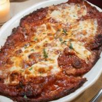 Eggplant Parmigiana · Egg battered eggplant topped with mozzarella cheese, parmigiano cheese, and tomato sauce.