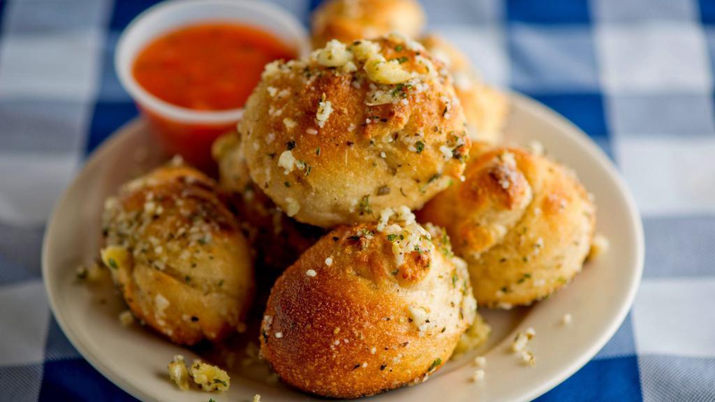 Garlic Knots · Fresh baked garlic knots served with a savory marinara dipping sauce.