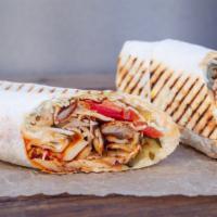 The Beef Shawarma · Delicious wrap made with seasoned beef, sliced tomatoes and pickles, served in a white, flou...