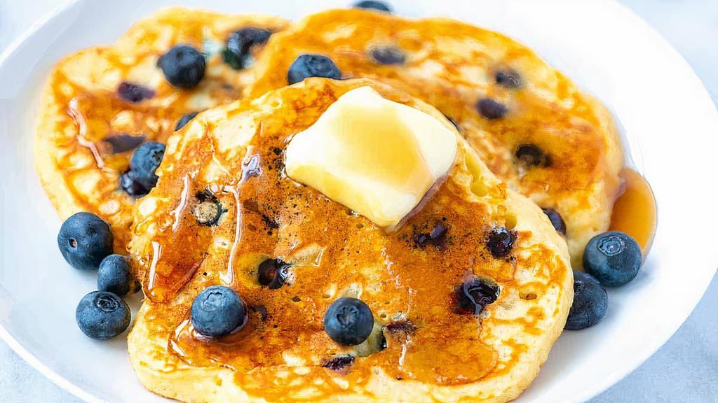 Blueberry Pancakes · Buttermilk pancakes with plump blueberries and lightly dusted with powdered sugar. Served with whipped butter and syrup.