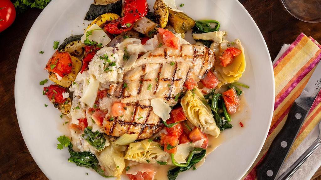 Mediterranean Chicken · A grilled chicken breast topped with sautéed fresh spinach, seasoned plum tomatoes, artichoke hearts, white wine, and garlic, all on a bed of garlic mashed potatoes. With your choice of side.