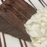 Delightfully Decadent Chocolate Cake · With chocolate sauce and whipped cream.