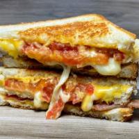 Baconcheesy · American and Jack cheese, bacon and tomato melted in-between three slices of buttery topped ...
