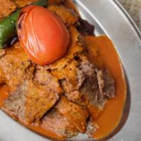 Iskender Kebab · Vertically grilled lamb sliced very thin and served with garlic yogurt and tomato sauce on p...
