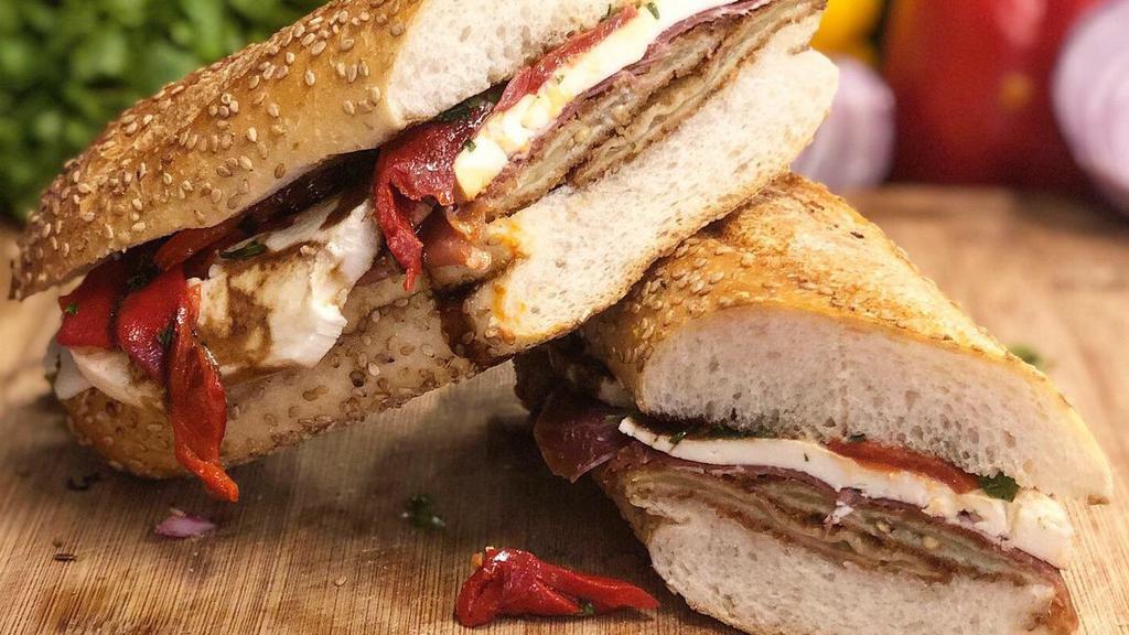 Cousin Vinny · Eggplant cutlet, fresh mozzarella, Parma prosciutto, roasted peppers, balsamic glaze, and extra virgin olive oil served on a seeded semolina roll.