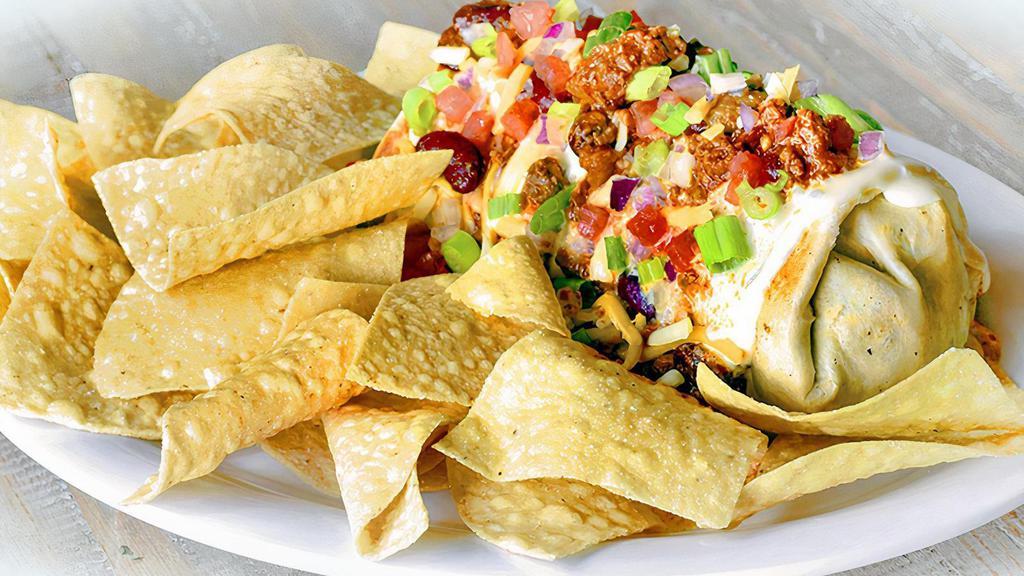 Smothered Burgerito · A seasoned all-beef pepper jack cheeseburger chopped and wrapped in a flour tortilla and topped with warm queso, chili, shredded cheddar jack cheese, diced tomatoes and green onions. Served with a side of tortilla chips. (1630 cal.)