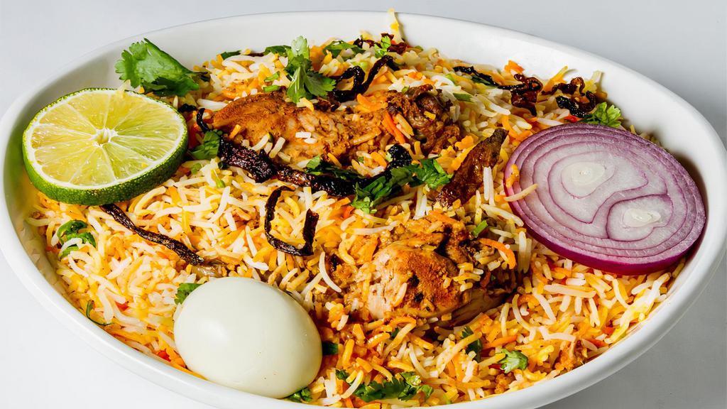 Chicken Dum Biryani · Spicy, gluten free. Uniquely layered Hyderabadi biryani (Persis) cooked in a traditional Nawabi way then garnished with egg, onion and lemon. Served with yogurt raita and special gravy.