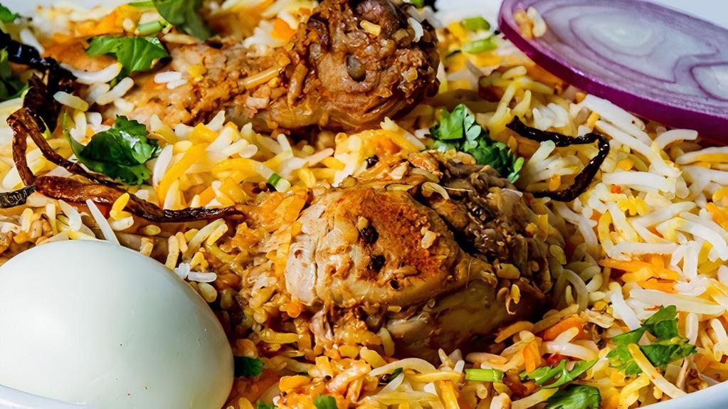 Goat Dum Biryani · Spicy, gluten free. Basmati rice cooked with goat meat, herbs, spices and garnished with onion and lemon in traditional Hyderabadi style. Served with yogurt raita and special gravy.