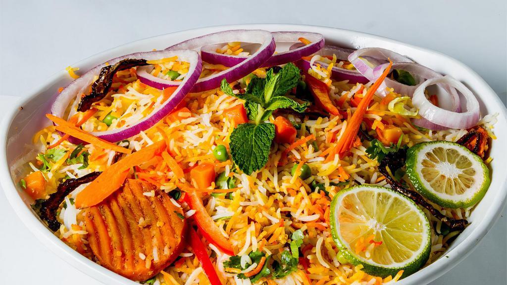 Vegetable Biryani · Spicy, gluten free. Basmati rice cooked with vegetables, herbs, spices and garnished with onion and lemon. Served with yogurt raita and special gravy.