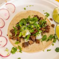 Carne Asada / Grilled Steak Taco · Served on fresh soft corn or flour tortilla, finished with freshly cut white onions, cilantr...