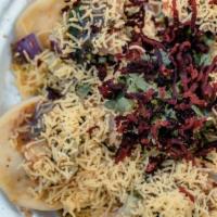 Sev Poori · Crisp  flat papdi topped with tamarind, mint, and garlic chutneys, masala and topped with ny...