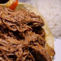 Vaca Frita · Pan-fried shredded flank steak seasoned with garlic and lemon juice.