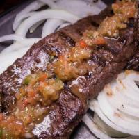 Bistec De Palomilla · Traditionally marinated, thinly sliced Cuban steak sautéed on the flat griddle and topped wi...