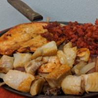 Pollo Feliz · Grilled chicken breast, shrimp, fish, bacon and chorizo over a bed of sautéed onions and mus...