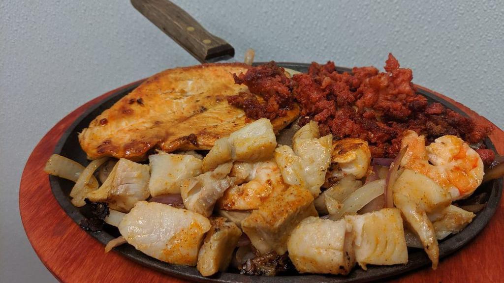 Pollo Feliz · Grilled chicken breast, shrimp, fish, bacon and chorizo over a bed of sautéed onions and mushrooms topped with cheese dip served with Mexican rice, beans and tortillas.