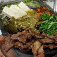 Molcajete · A traditional Mexican dish with grilled chicken breast, rib-eye steak, shrimp, Mexican sausa...