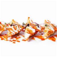 *Crispy Dragon* · Lightly fried wontons stuffed with spiced grilled chicken, green and red onions, finished wi...