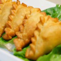 Curry Puffs · Filling is made with potatoes and green peas. Served with peanut sauce and cucumber sauce.