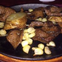 Anticuchos · Marinated veal heart kabobs, potatoes and corn.