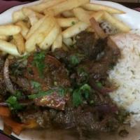 Lomo Saltado · Sautéed strips of beef with onions and tomatoes, served with French fries and rice.