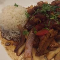 Pollo Saltado · Sautéed strips of chicken with onions and tomatoes, served with French fries and rice.