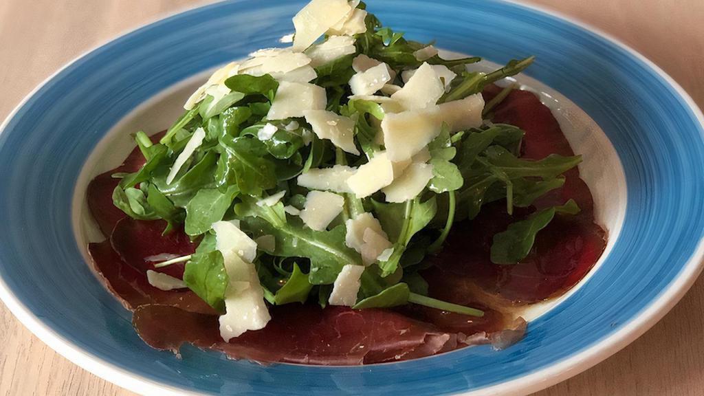 Carpaccio Di Bresaola · Carpaccio di bresaola (cured beef) whit arugula and shaved Parmigiano topped with lemon dressing.