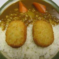 Vegetable Croquette Curry · Vegetable croquette with golden curry sauce on white rice.