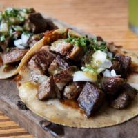 Brisket Tacos · Braised brisket adobo tacos, banana leaf, guajillo, crispy chihuahua cheese. Fresh house-mad...