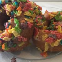 Cereal Killer · Vanilla cake dipped in honey glaze glaze topped with fruity pebbles.