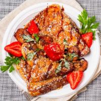 Mexican French Toast · French toast served with strawberries, sweet plantains, and granola. Topped with white choco...