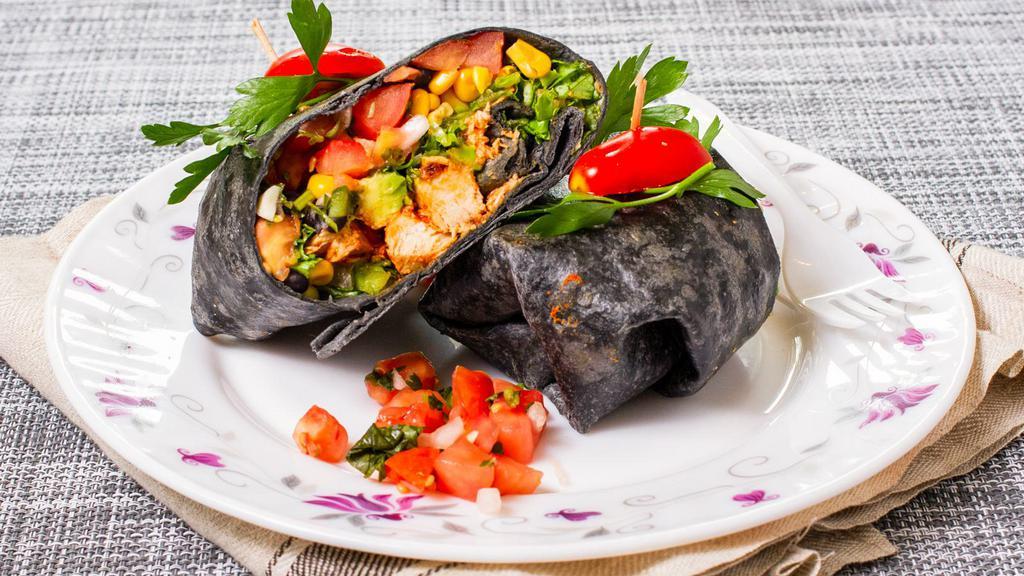Chicken Veracruz Wrap · Made with grilled chicken, avocado, black beans, corn salad, and lettuce. Served in a black bean wrap.