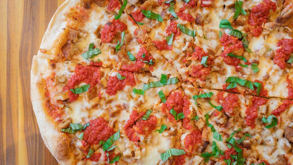 Chicken Parmigiana Pizza · Crispy round crust topped with cubed breaded chicken, garlic tomato sauce and mozzarella.