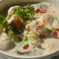 Tom Kha Soup · Spicy. White mushroom, scallion, cilantro, and chili paste oil in coconut galangal soup.