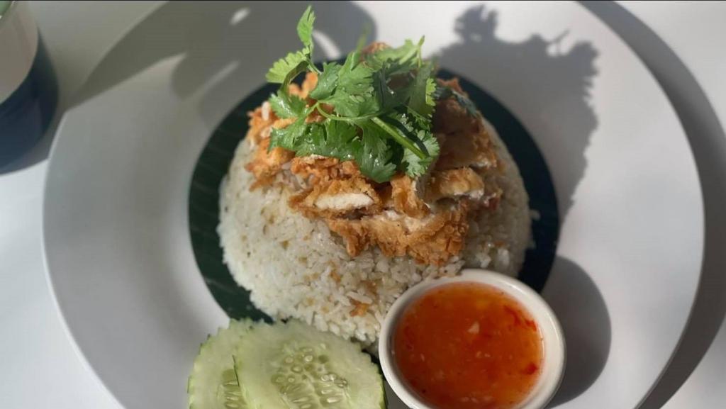 Kao Mun Gai Tod · Spicy. Crispy homemade fried chicken over chicken stock rice with ginger sauce and sweet chili sauce on the side.