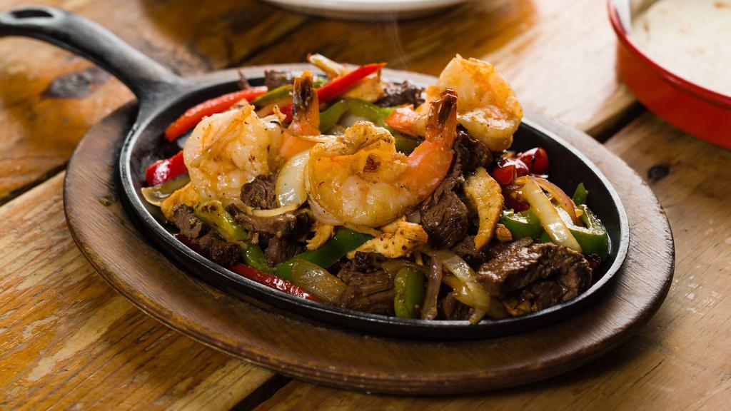 Supreme Fajitas · Combo of chicken, steak and shrimp. Choice of tortilla with sauteed poblano peppers, bell peppers, onions and roasted tomato sauce with guacamole, crema fresca, pico de gallo, rice and beans.