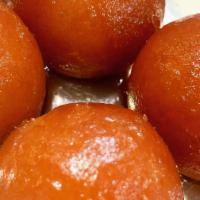 Gulab Jamun · Soft roundels of cottage cheese stuffed with diced pistachios and simmered in a honey syrup.