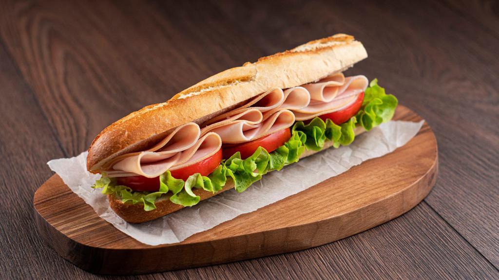 Caprese Sandwich · Delicious sandwich made with fresh baguette, mozzarella cheese, basil pesto, arugula, dried tomato tapenade, and a balsamic glaze.