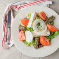 Greek Salad · Tossed garden salad topped with feta cheese, kalamata olives, stuffed grape leaves and ancho...