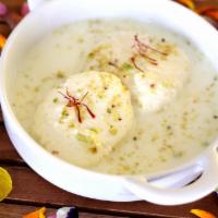 Rasmalai · Sweet dumplings of cottage cheese served in chefs special flavored milk, garnished with pist...