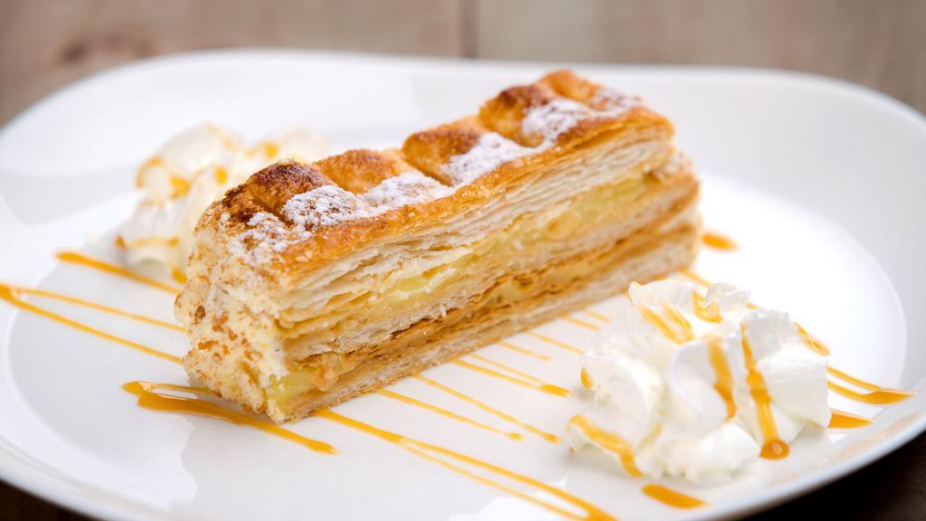 Napoleon · Crisp layers of puff pastry filled with pastry cream and decorated with powdered sugar.