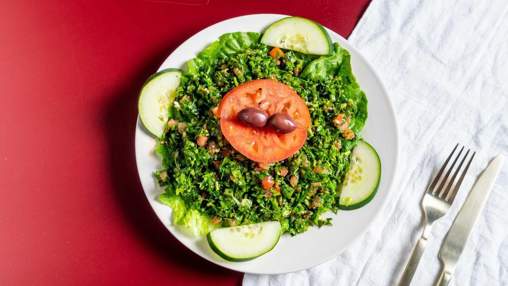 Tabouli Salad · A healthy Lebanese salad. Made with fresh parsley, tomato, onion, extra virgin olive oil, bulgur wheat and lemon juice.