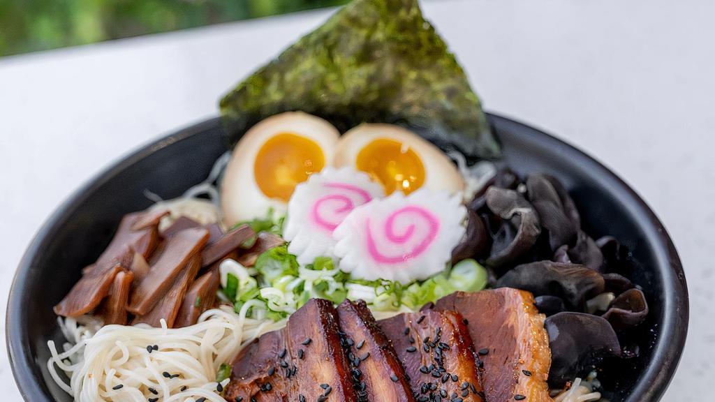 Spicy Tonkotsu (Soy Based Soup)* · Ten-twelve Hour Pork Broth, Braised Pork, Soft Boiled Egg, Cabbage, Scallions, Wood Ear Mushrooms, Bamboo Shoots, Naruto, Nori, Savory Spicy Sauce, and Black Garlic Truffle Oil. Topped with Sesame Seeds.