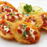 Potato Skins · Warm, stuffed potato wedges with crumbled bacon, melted cheddar cheese and fresh scallions.
