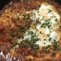 Palestinian Shakshouka · Two eggs nestled in stewed tomatoes, onions, peppers, garlic and parsley (mild). Served with...