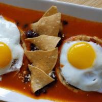 Huevos Rancheros · 2 soft tortillas topped with refried beans, sunny side eggs, salsa ranchera, queso fresco, s...